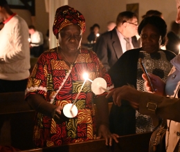 Two members of the congregation light candles