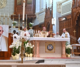 Bishop James Ruggieri at the altar during the Liturgy of the Eucharist. A picture of Pope Francis is in the foreground in front of the abmo.