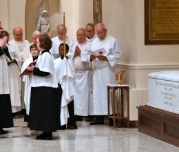 Bishop James Ruggieri, surrounded by priests and deacons, blesses the tomb of Bishop David Bacon.