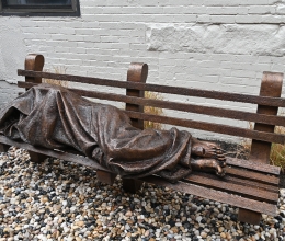 sculpture of mass sleeping on a bench