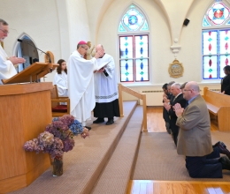 Bishop Ruggieri prays over the kneeling deacon candidates.