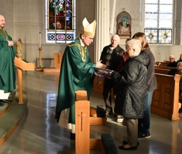 Bishop James Ruggieri hands the Matthew 25 Award to volunteers