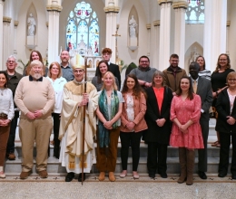 Bishop pictured with large group in front of the altar