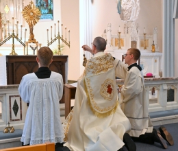 Bishop James Ruggieri incenses the altar and the monstrance. Seminarians Joseph Beale and Nicholas Hershbine are kneeling on either side of him.