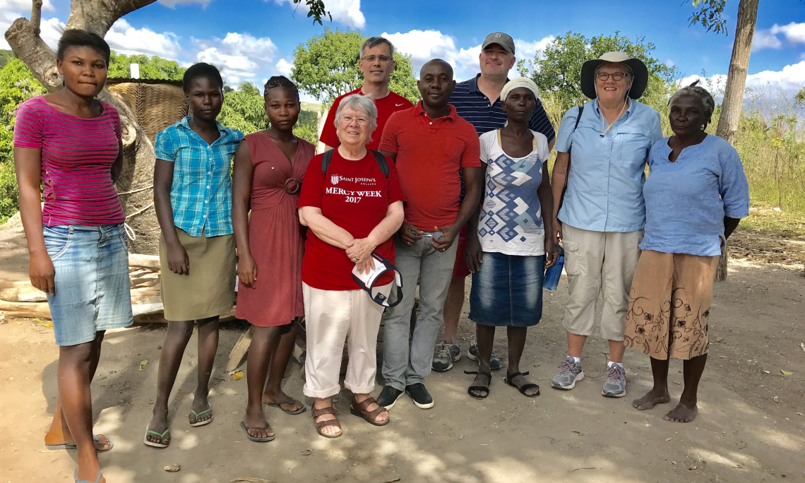 Sister Dale Jarvis, RSM with caseworkers and a family in Haiti.