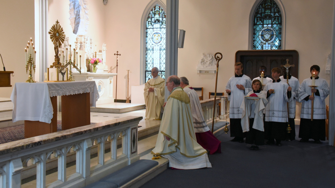 Bishop Robert Deeley kneels in eucharistic adoration