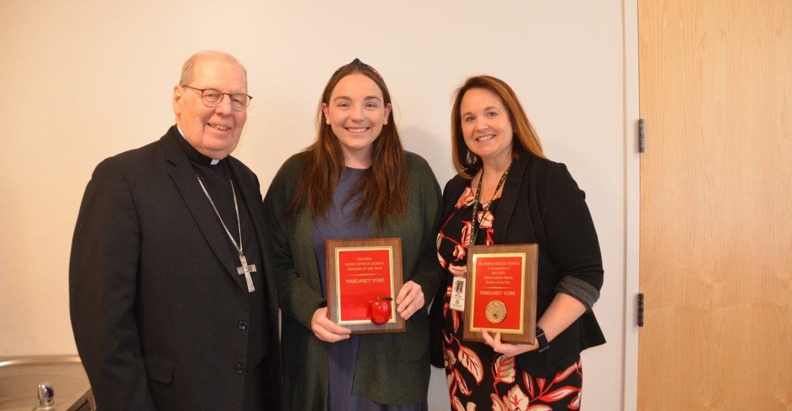 three people holding awards