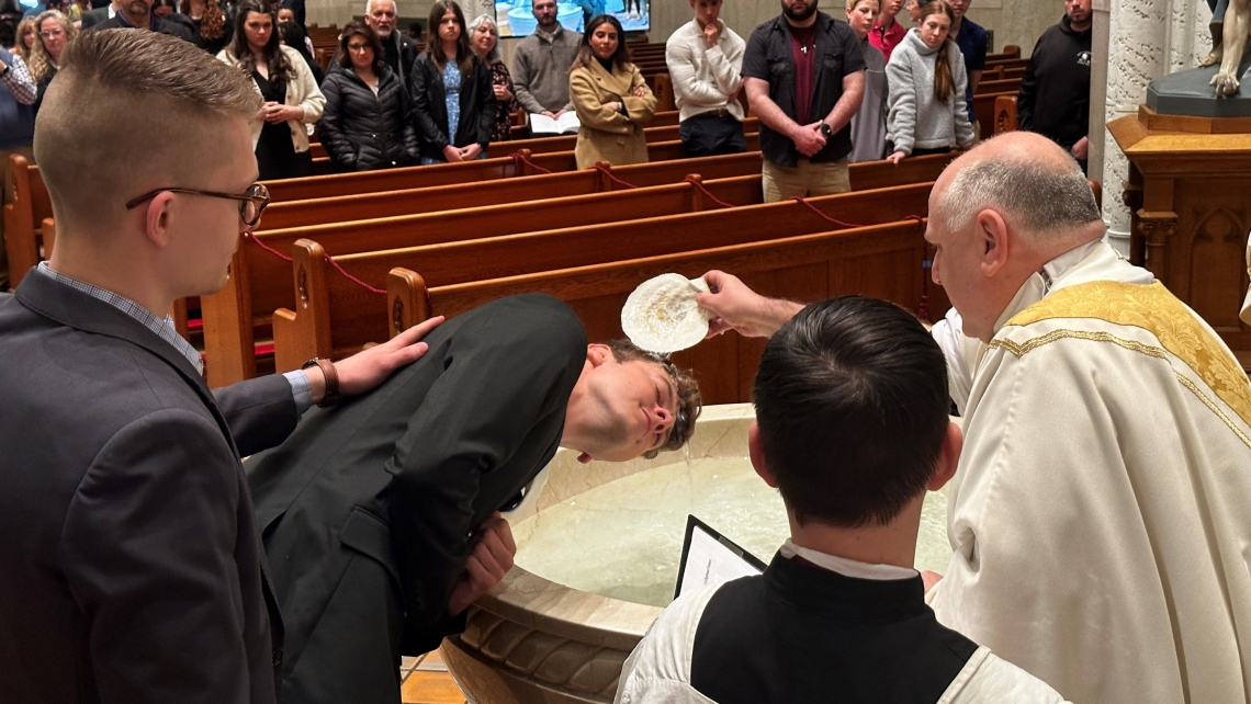 Jonathan Gordon is baptized by Father Daniel Greenleaf.
