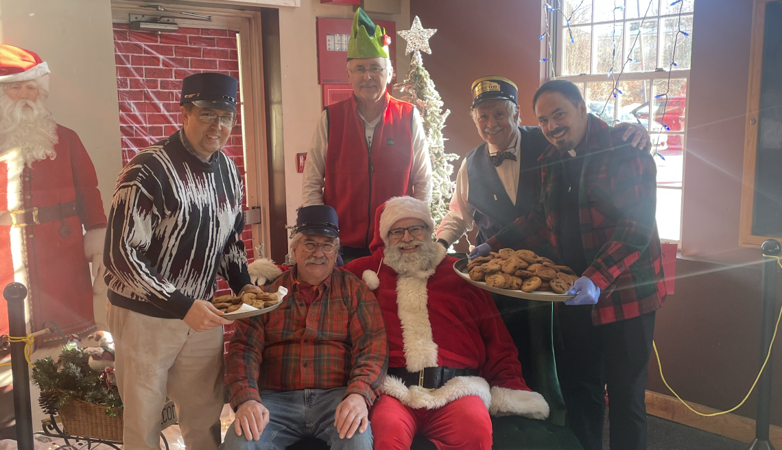 Group surrounding a Santa Claus seated