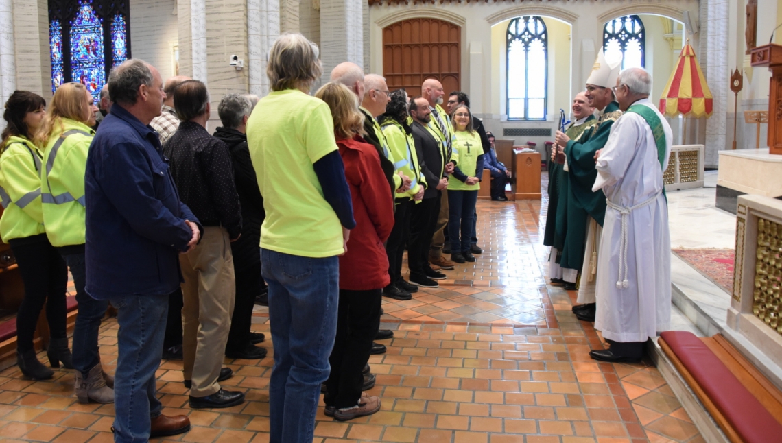 Bishop Ruggieri presents the Matthew 25 Award to a group of volunteers.