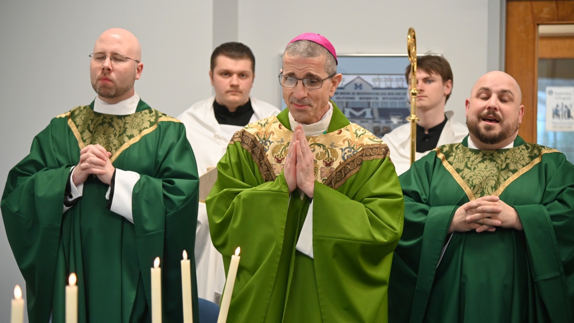 Bishop James Ruggieri, Father Kyle Doustou, Father Brad Morin, and student altar servers