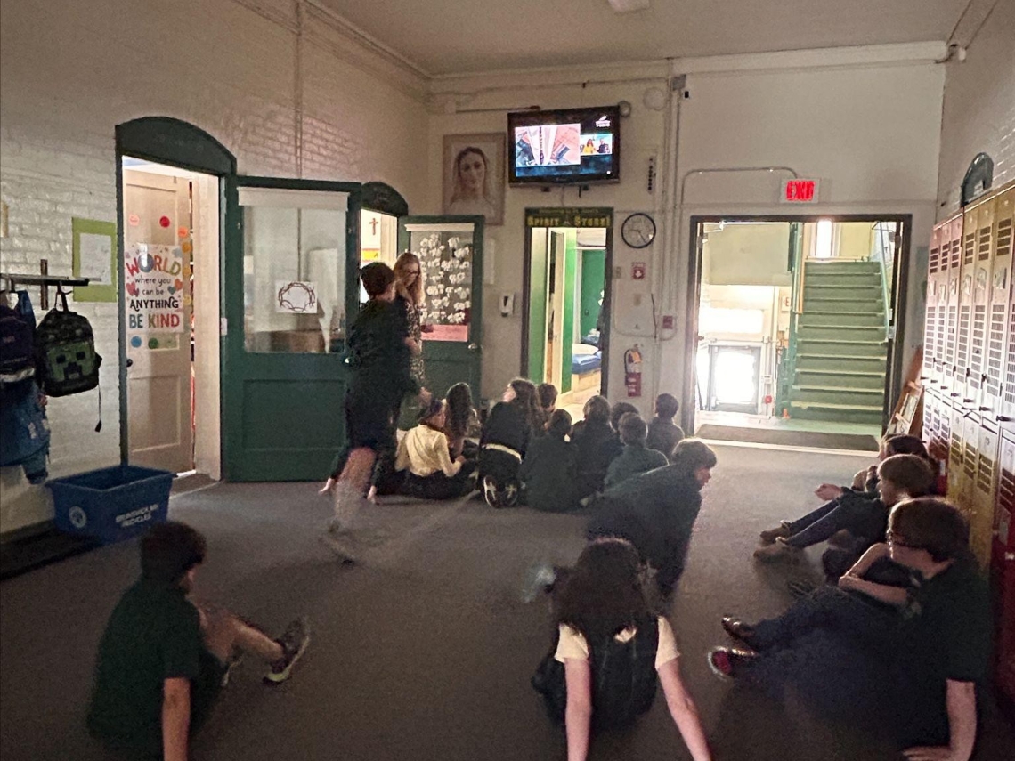 Students at St. John's school gather in front of a tv to watch the Blue Origin Launch