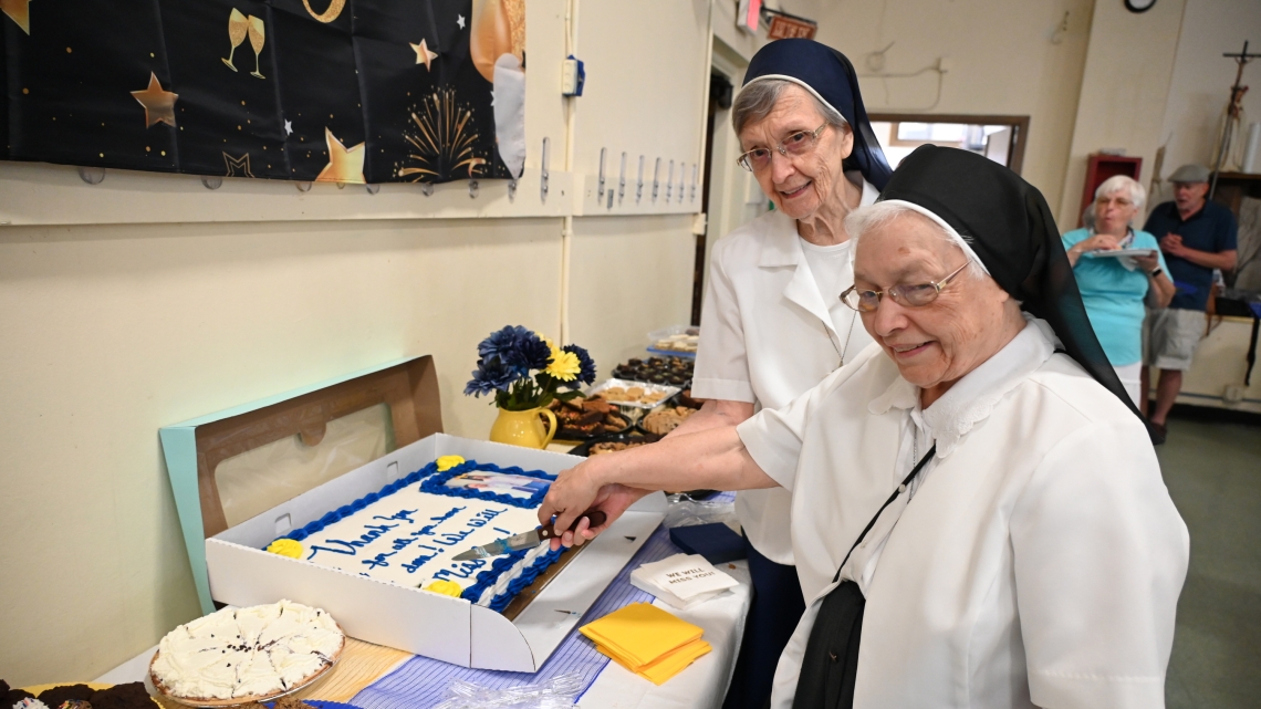 Sister Cecile Mondor and Sister Marie May Lausier cut a cake wishing them well.
