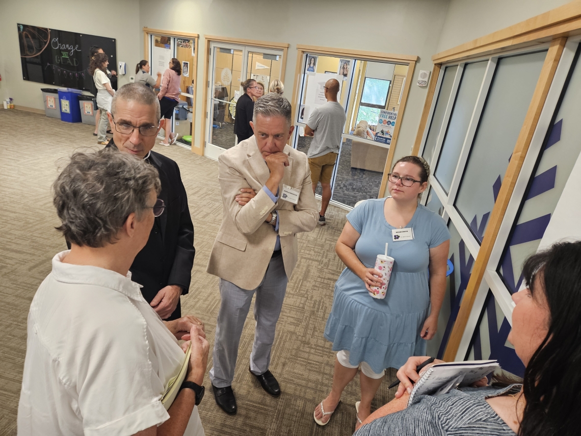 bishop speaking to a small group