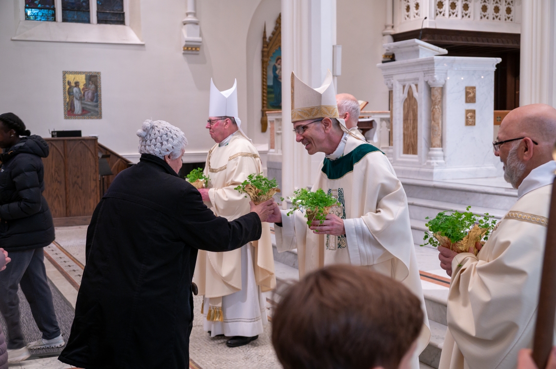 clergy handing out shamrocks after Mass
