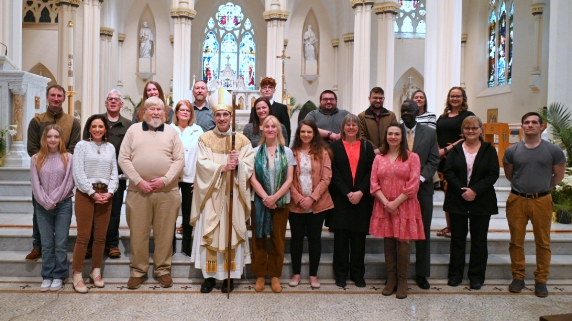 Bishop pictured with large group in front of the altar