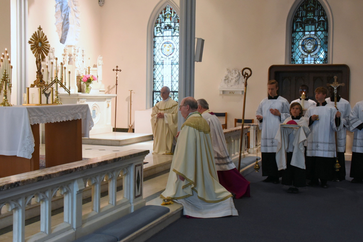 Bishop Robert Deeley kneels in eucharistic adoration