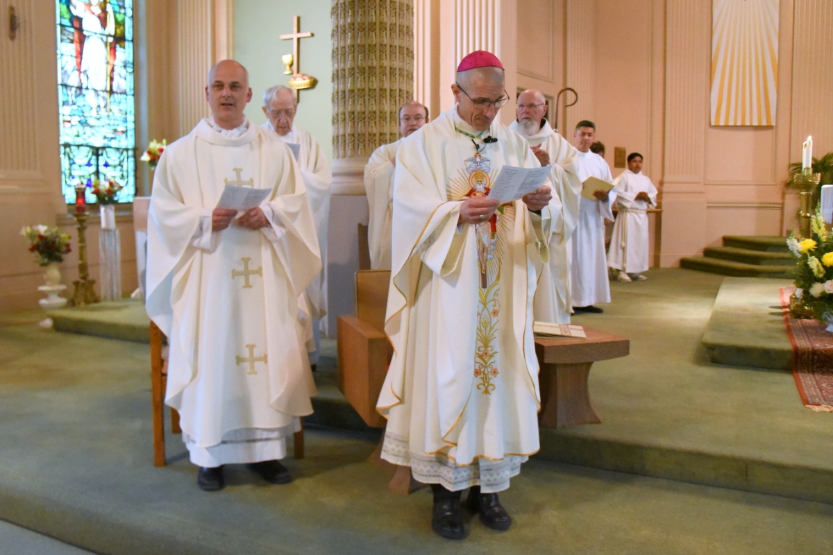 Bishop Ruggieri with Father Seamus Griesbach to his left and other priests behind him.