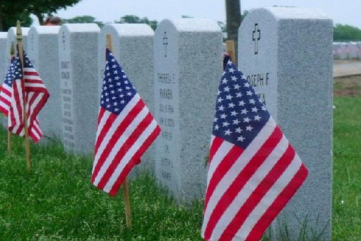 american flags in front of gravestones