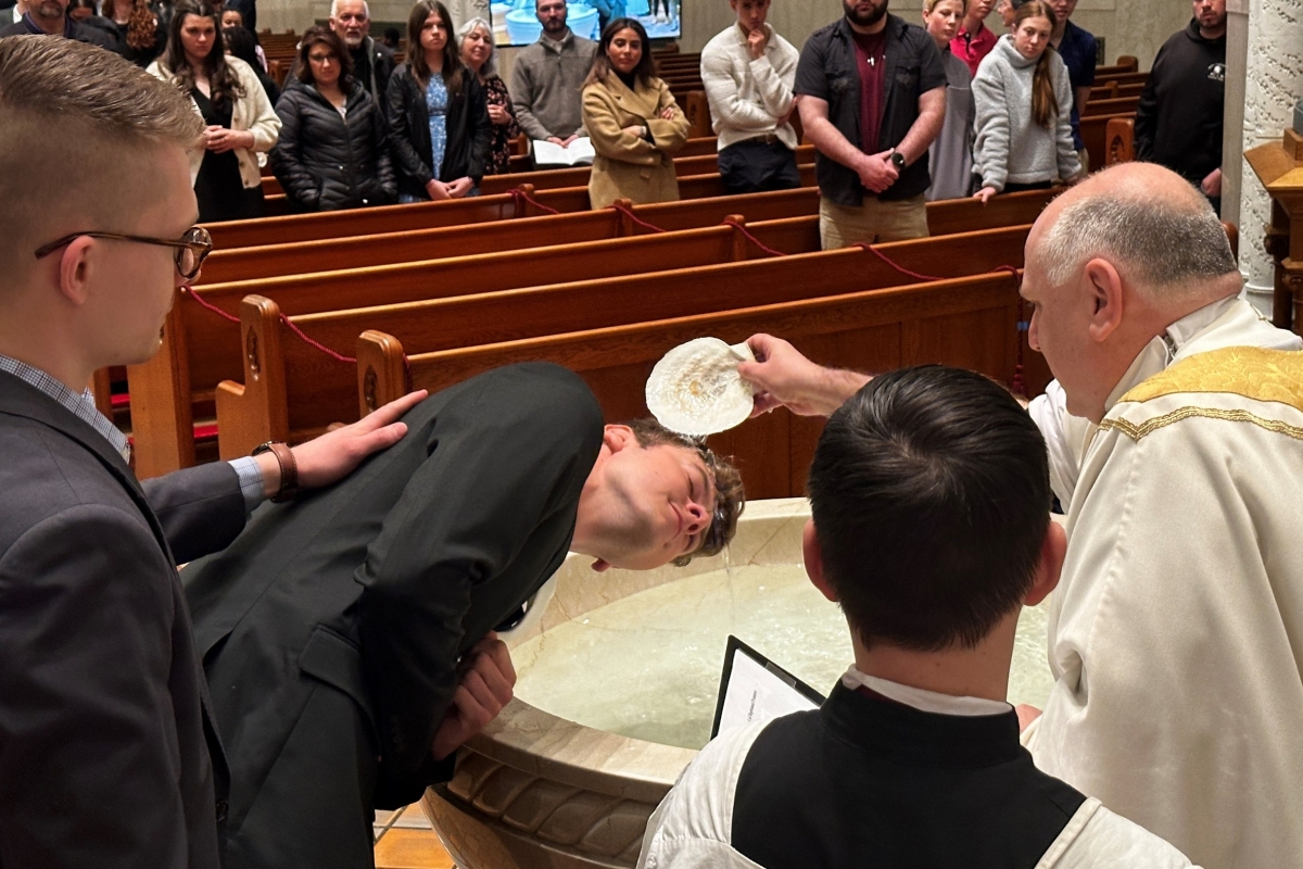 Jonathan Gordon is baptized by Father Daniel Greenleaf.