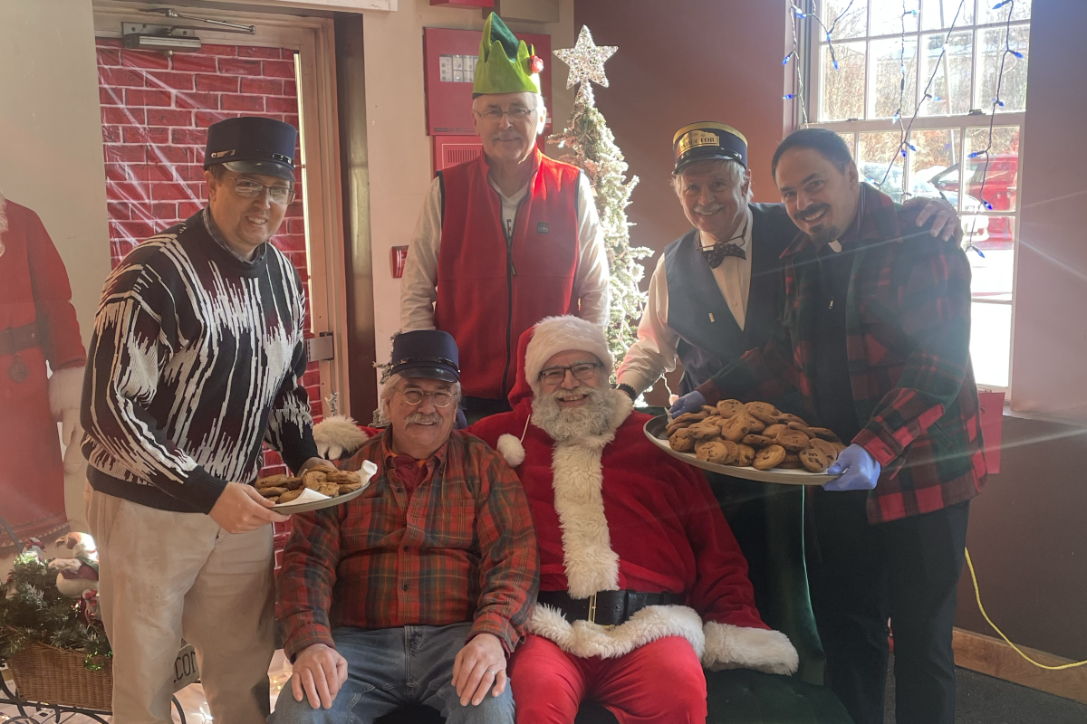 Group surrounding a Santa Claus seated