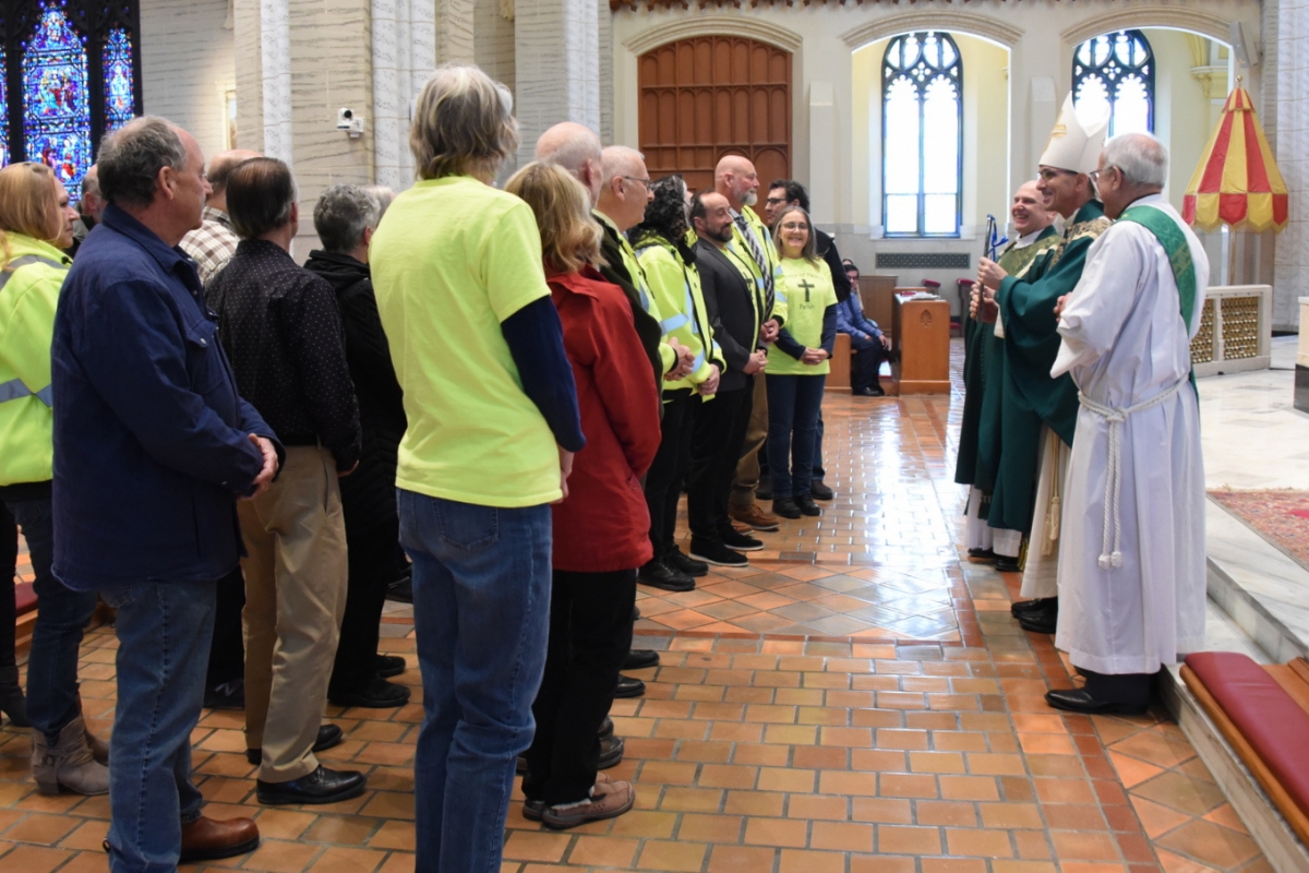 Bishop Ruggieri presents the Matthew 25 Award to a group of volunteers.