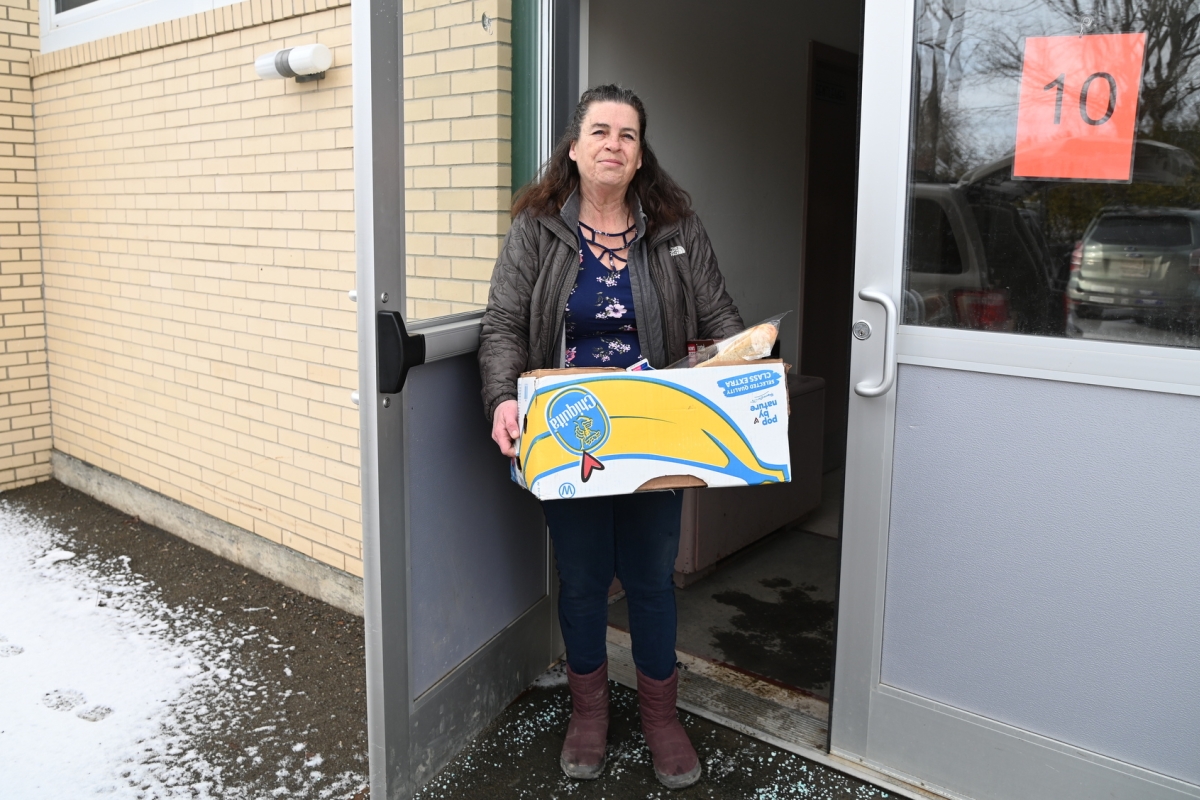 Donna Lathrop carrying a box of food