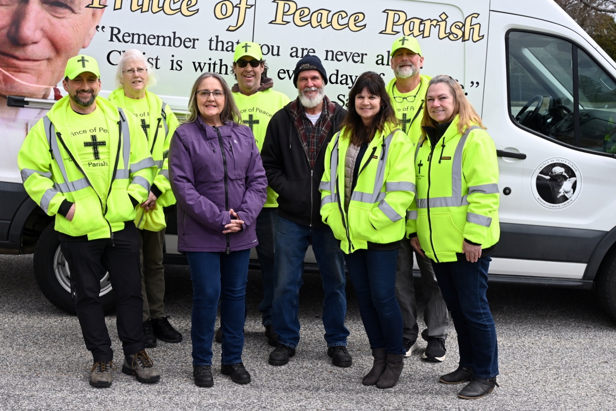 Volunteers with the Cross The Street Ministry standing in front of their food truck