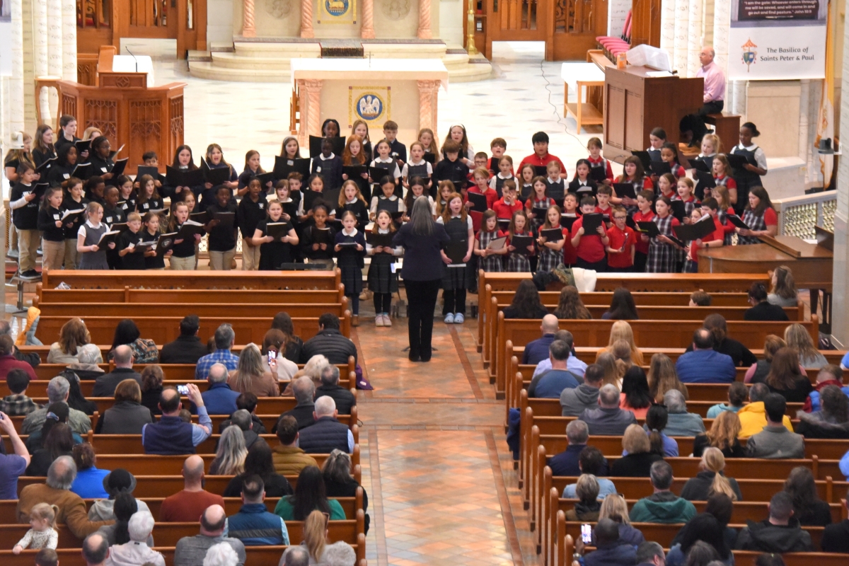 Students singing with people in pews.