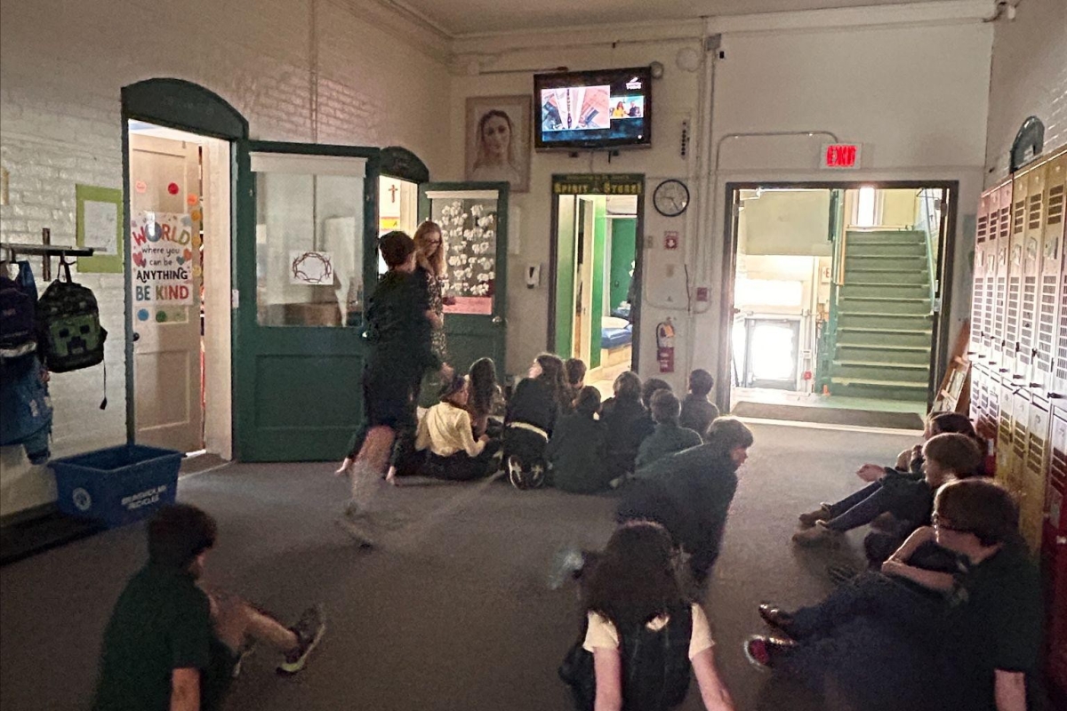 Students at St. John's school gather in front of a tv to watch the Blue Origin Launch