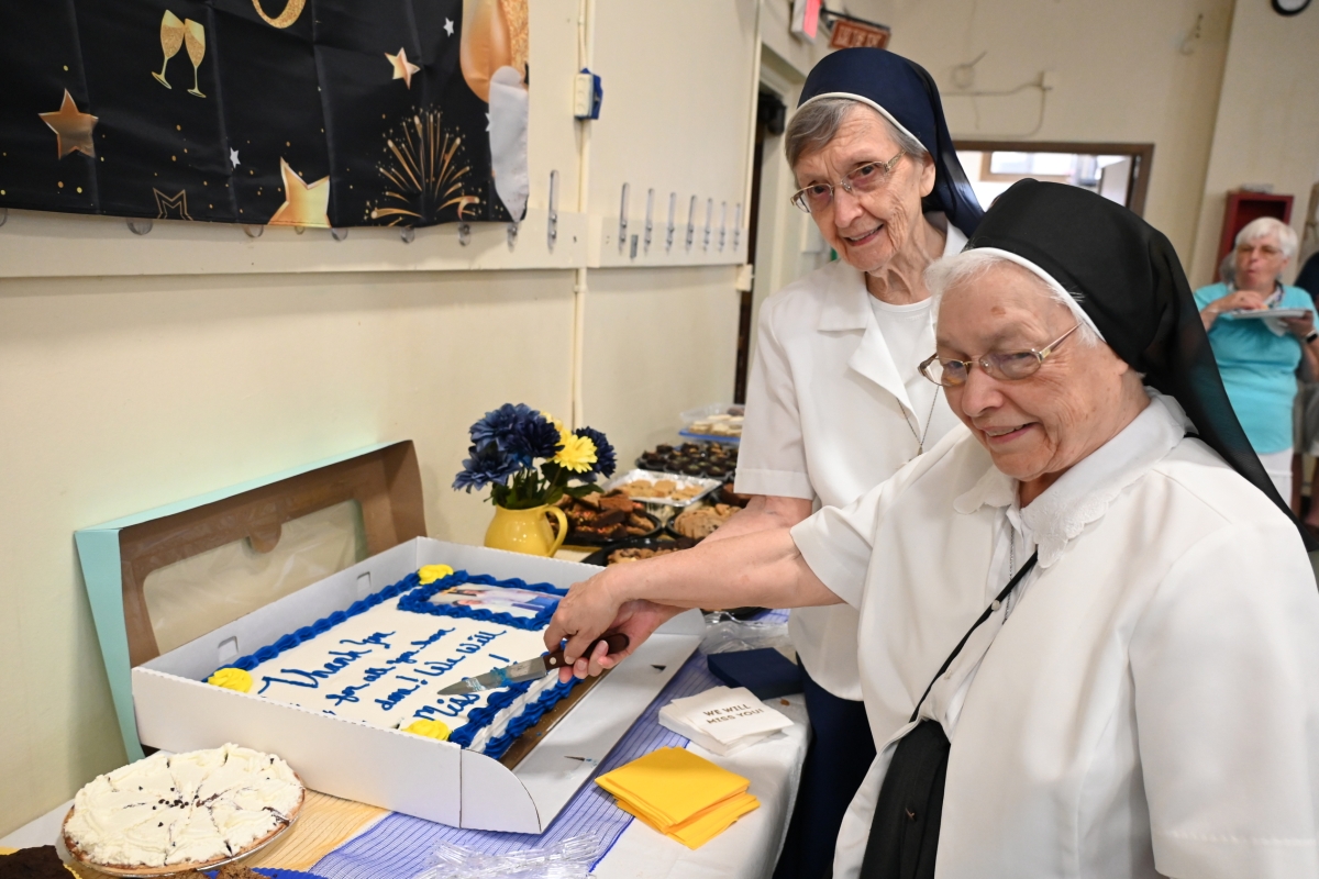 Sister Cecile Mondor and Sister Marie May Lausier cut a cake wishing them well.