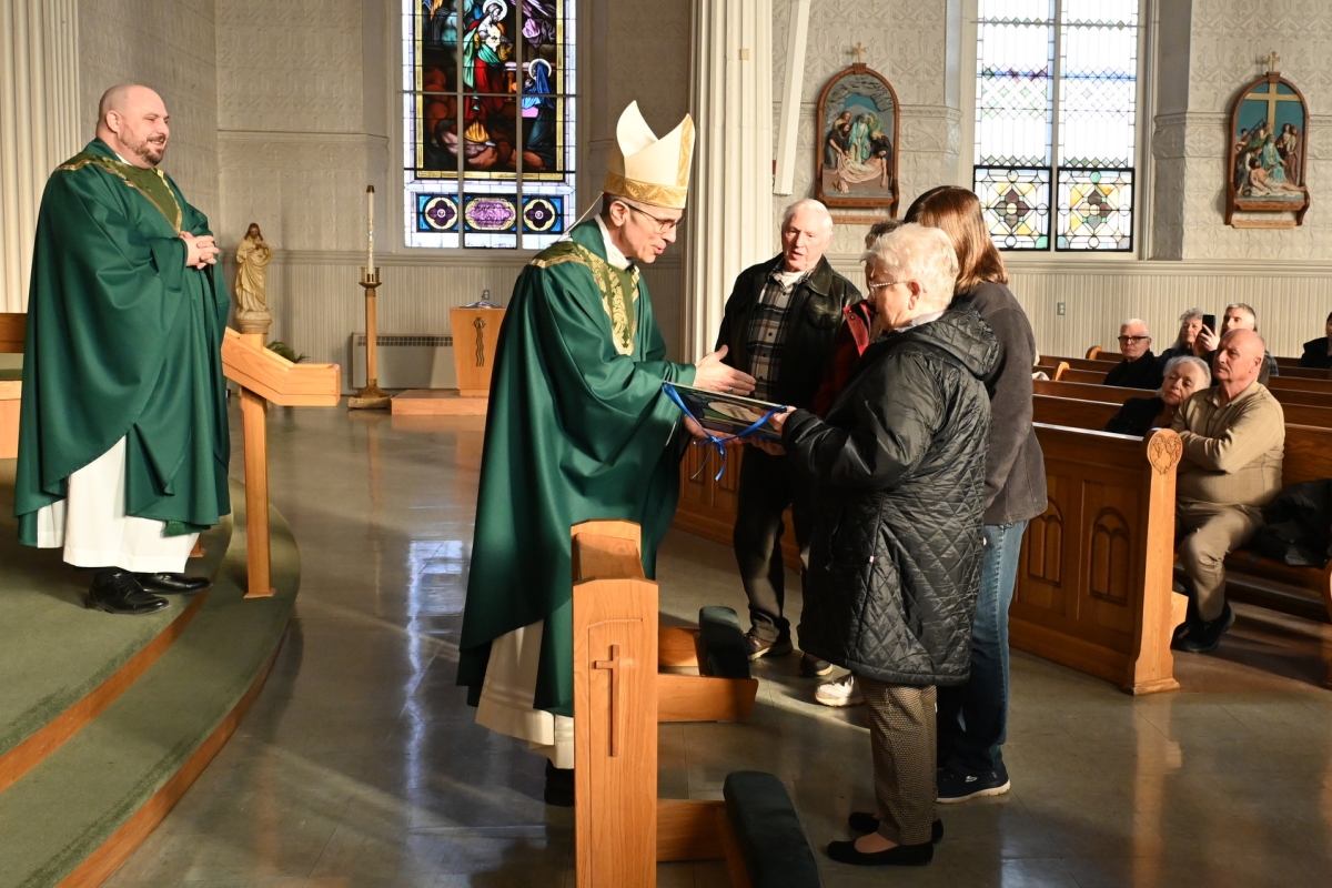 Bishop James Ruggieri hands the Matthew 25 Award to volunteers