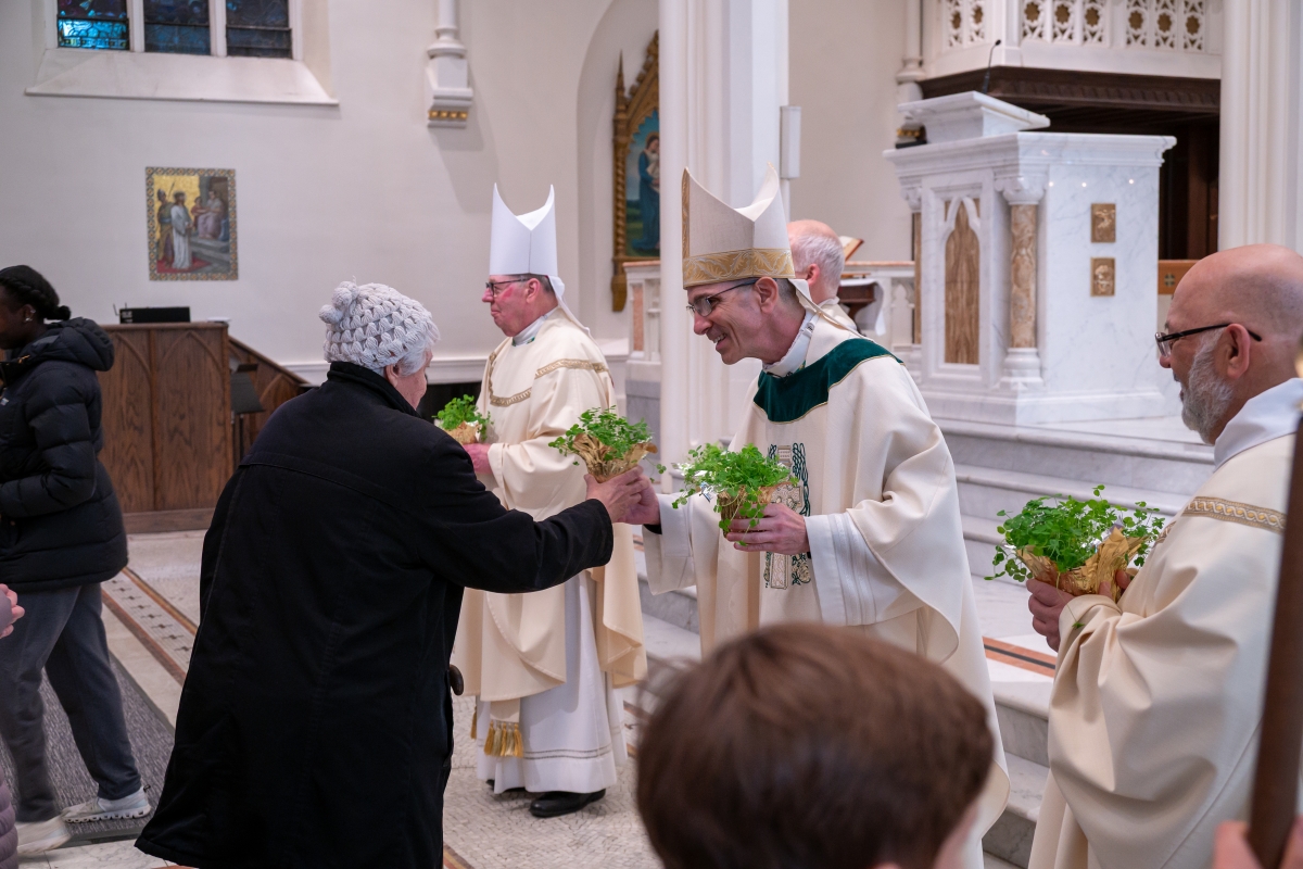 clergy handing out shamrocks after Mass